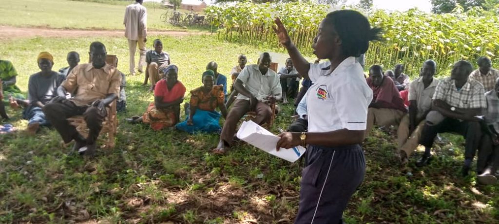 A facilitator speaking with a farming community outdoors